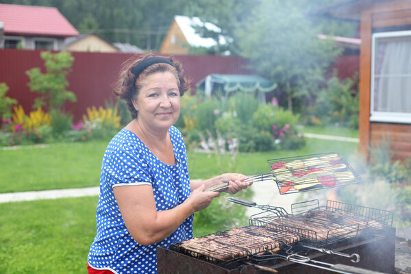 Woman Cooking On A Barbeque in the garden