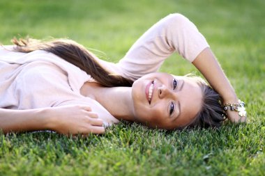 genç kadın bir yeşil çim üzerinde yalan