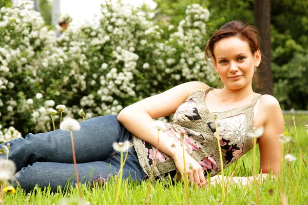 緑の芝生に横になっている若い女性 — ストック写真