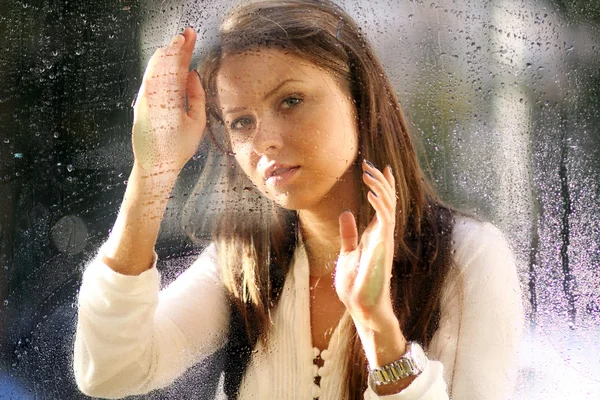 Junge Frau nach dem Regen am Fenster — Stockfoto