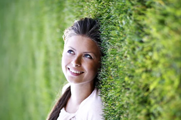 Jonge vrouw liggend op een groen gazon — Stockfoto