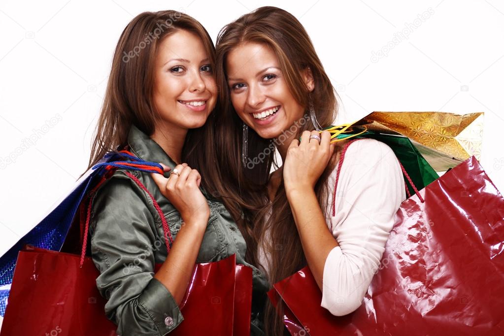 Sisters holding shopping bags on white isolated 