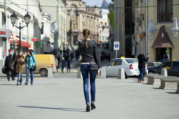 Mujer joven caminando por la calle — Foto de Stock