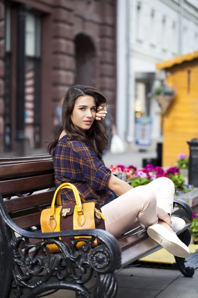 Young urban woman sits on a bench — Stock Photo, Image