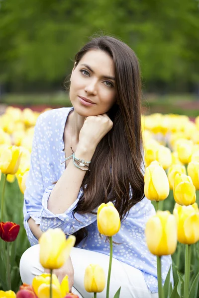 Jonge vrouw met tulpen — Stockfoto