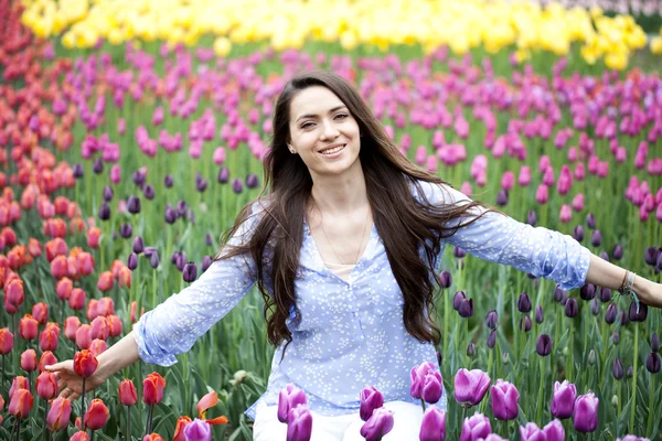 Jonge vrouw met tulpen — Stockfoto