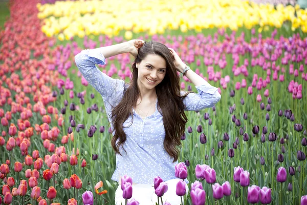 Jonge vrouw met tulpen — Stockfoto