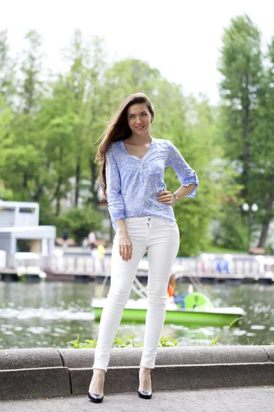 Ritratto a figura intera di una bella donna in pantaloni bianchi e blu — Foto Stock