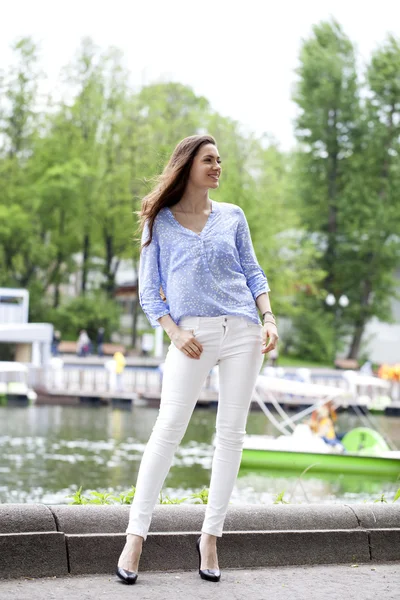 Retrato de larga duración de una hermosa mujer en pantalones blancos y blu —  Fotos de Stock