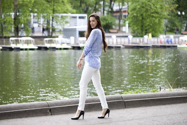 Full length portrait of a beautiful woman in white pants and blu — Stock Photo, Image