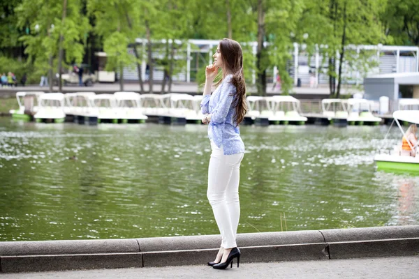 Полный портрет красивой женщины в белых брюках и голубом — стоковое фото