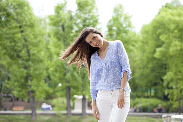Mujer joven feliz en pantalones blancos y camisa azul —  Fotos de Stock