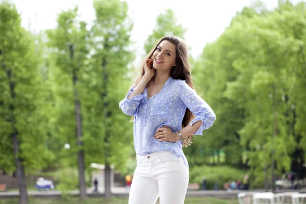 Felice giovane donna in pantaloni bianchi e camicia blu — Foto Stock