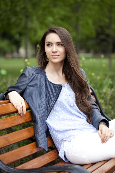 Brunette zittend op een bankje — Stockfoto