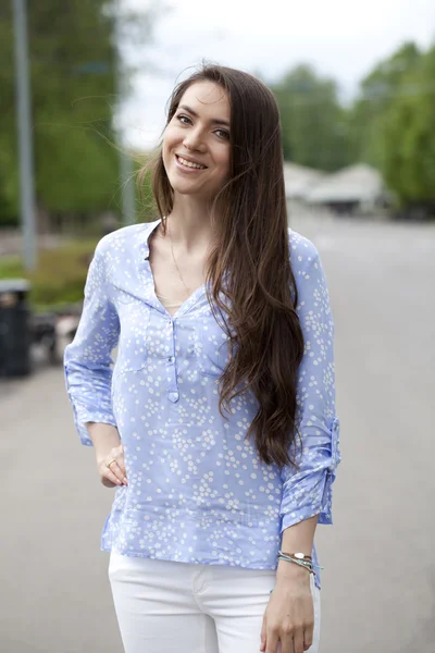 Joyeux jeune femme en pantalon blanc et chemise bleue — Photo