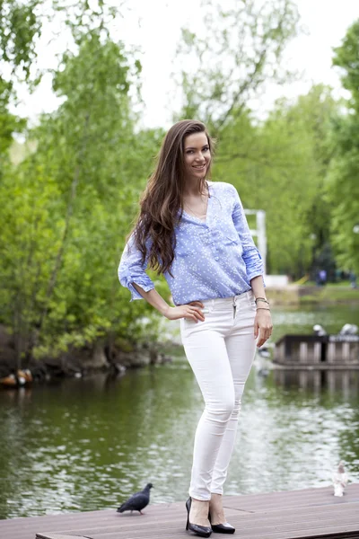 Retrato de larga duración de una hermosa mujer en pantalones blancos y blu —  Fotos de Stock