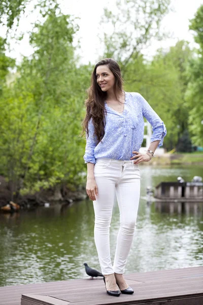 Ganzkörperporträt einer schönen Frau in weißen Hosen und blu — Stockfoto