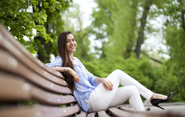 Bruna seduta su una panchina — Foto Stock