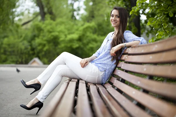 Morena sentado em um banco — Fotografia de Stock
