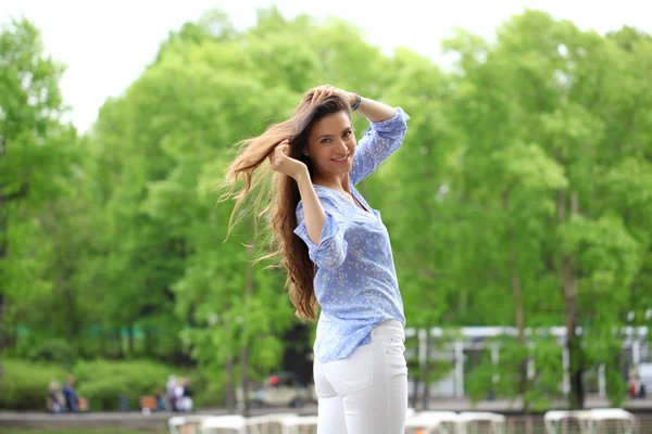 Joyeux jeune femme en pantalon blanc et chemise bleue — Photo