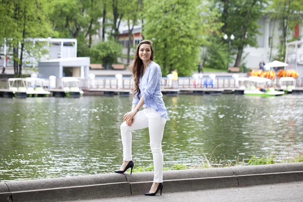 Full length portrait of a beautiful woman in white pants and blu — Stock Photo, Image