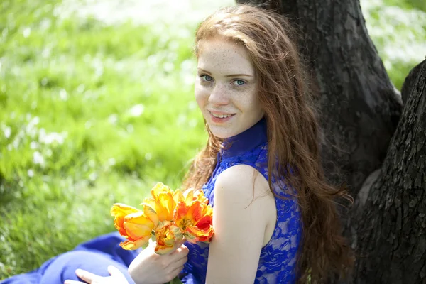 Νεαρό κορίτσι σε ένα χαλαρωτικό μπλε φόρεμα στο πάρκο άνοιξη — Φωτογραφία Αρχείου