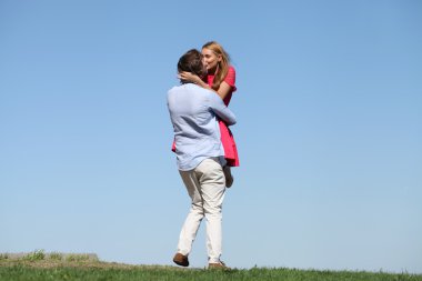 mutlu genç bir çift mavi gökyüzü üzerinde 