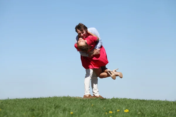 Young happy couple on blue sky — Stock Photo, Image