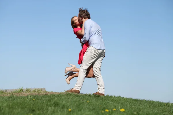 Young happy couple on blue sky — Stock Photo, Image