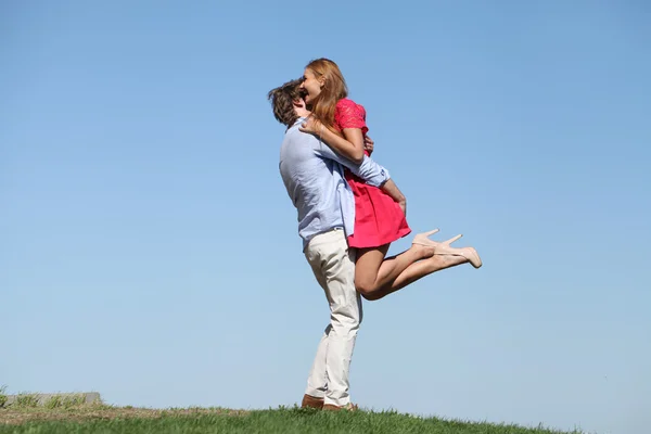 Young happy couple on blue sky — Stock Photo, Image