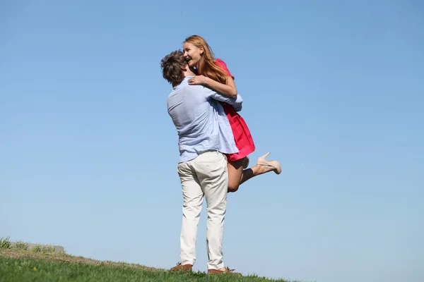 Joven pareja feliz en el cielo azul — Foto de Stock