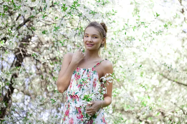 年轻漂亮的女孩站在开花的树木在春天 gard 附近 — 图库照片
