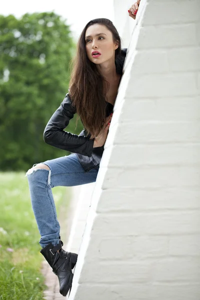 Sexy vrouw in lederen jas en blue jeans — Stockfoto