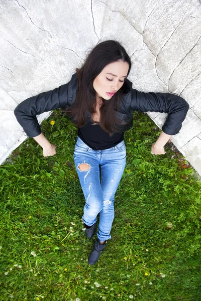 Сексуальная женщина в кожаной куртке и синих джинсах — стоковое фото