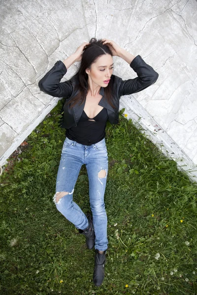 Sexy vrouw in lederen jas en blue jeans — Stockfoto