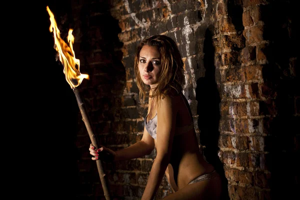 Mysterious sexy woman with torch in hand — Stock Photo, Image