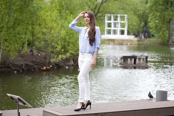 Full length portrait of a beautiful woman in white pants and blu — Stock Photo, Image