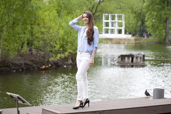 Full length portrait of a beautiful woman in white pants and blu — Stock Photo, Image