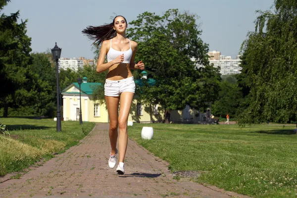 Young woman running in summer park — Stock Photo, Image