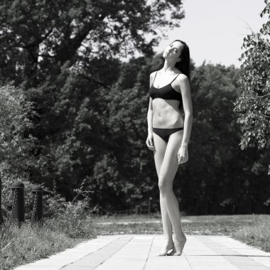 Yaz parkta yürüyen genç bir kadın 