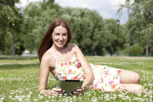 Portrait of young woman lying on a green lawn — Stock Photo, Image