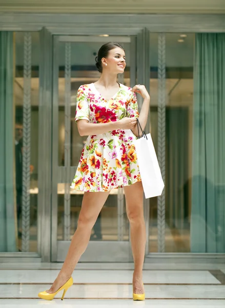 Junge schöne Frau im Kleid mit roten Blumen — Stockfoto