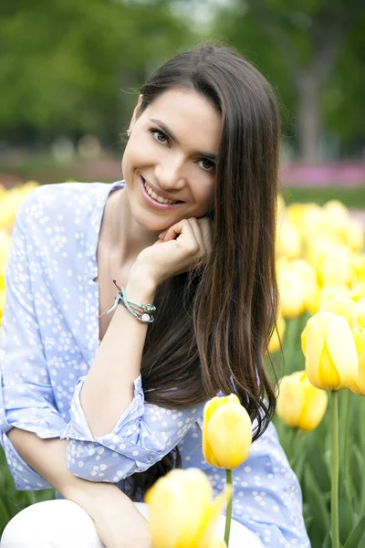 Schöne junge Frau mit Tulpen — Stockfoto