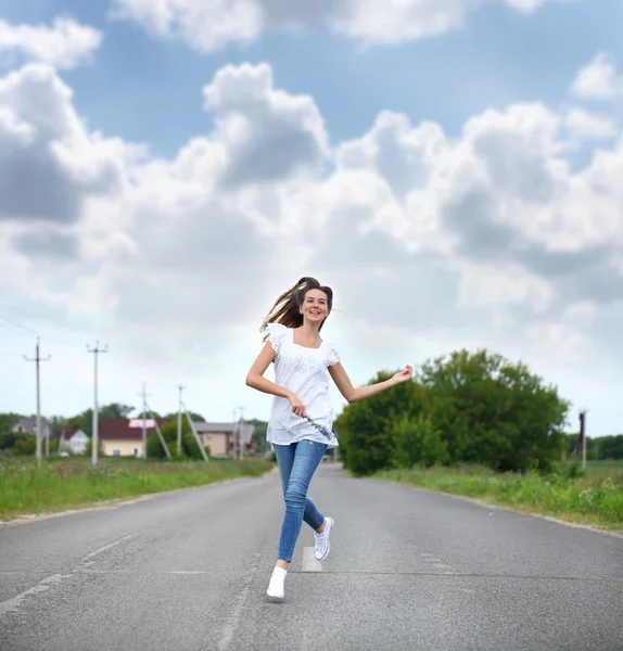 Mladá žena pobíhající po venkovské silnici — Stock fotografie