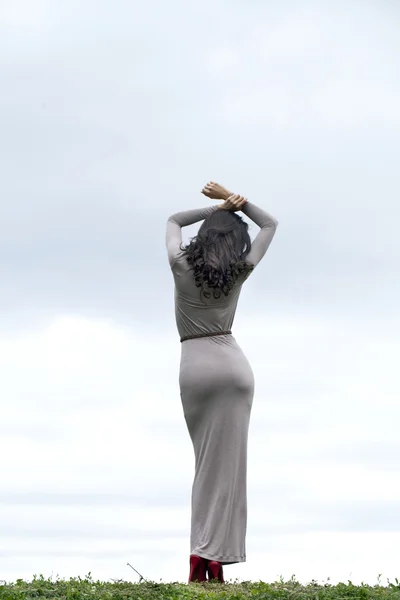 Νεαρή γυναίκα σε σέξι φόρεμα μακρύ γκρίζο — Φωτογραφία Αρχείου