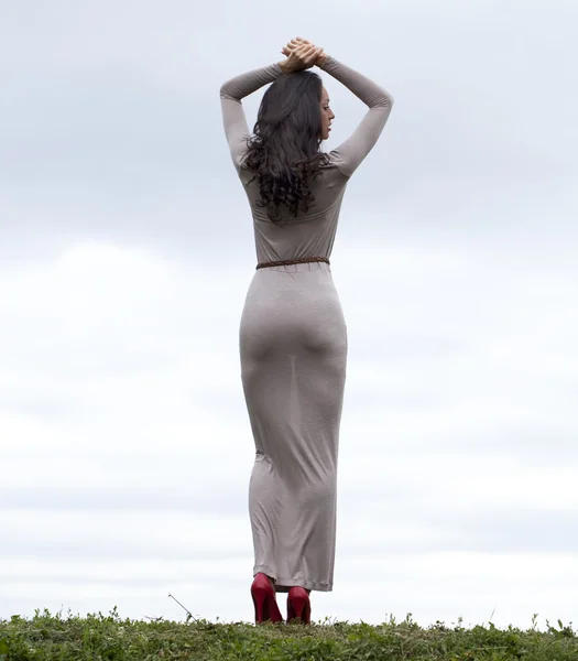 Młoda kobieta długo szara sukienka — Zdjęcie stockowe