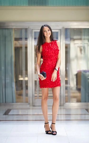 Schöne Frau im roten Kleid im Geschäft — Stockfoto