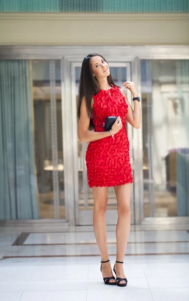 Mulher bonita em vestido vermelho na loja — Fotografia de Stock