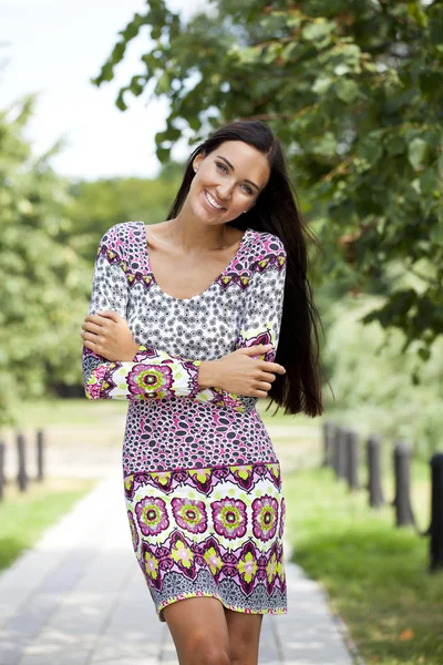 Mooie jonge vrouw in kleurrijke jurk — Stockfoto