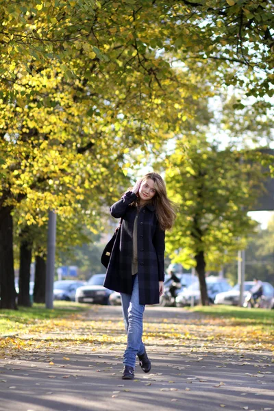 Bella giovane donna a piedi nel parco autunnale — Foto Stock